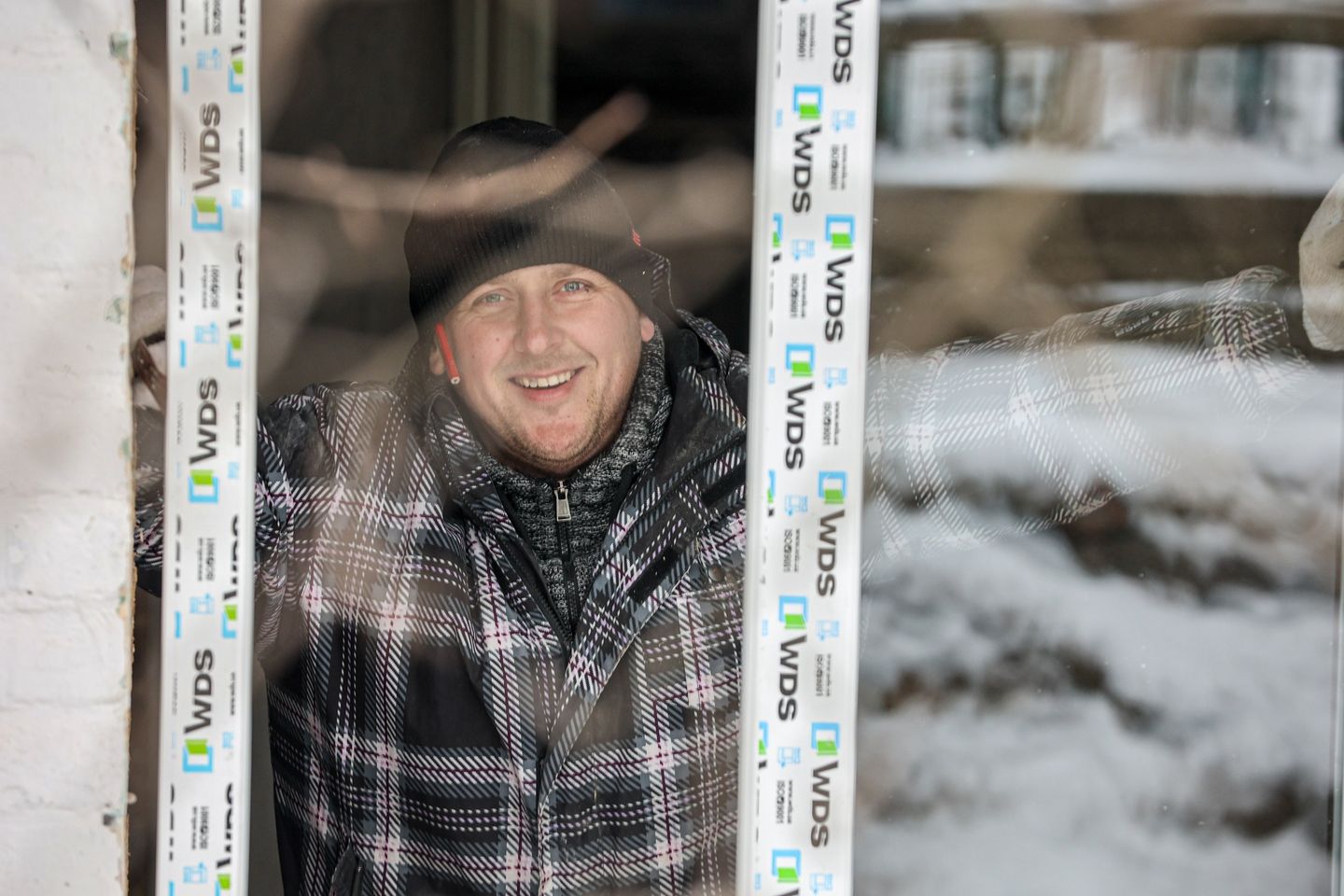 Volunteer Smiles To Camera While Installing A Window In Kherson