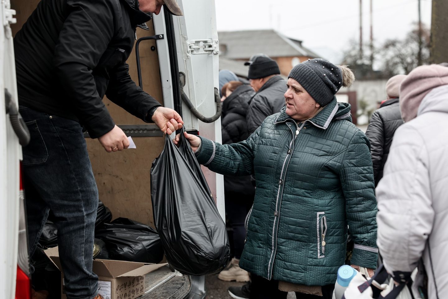 Elderly Ukrainian Woman Receiving Bag With Aid From A Volunteer Elderly Ukrainian Woman Receiving Bag With Aid From A Volunteer
