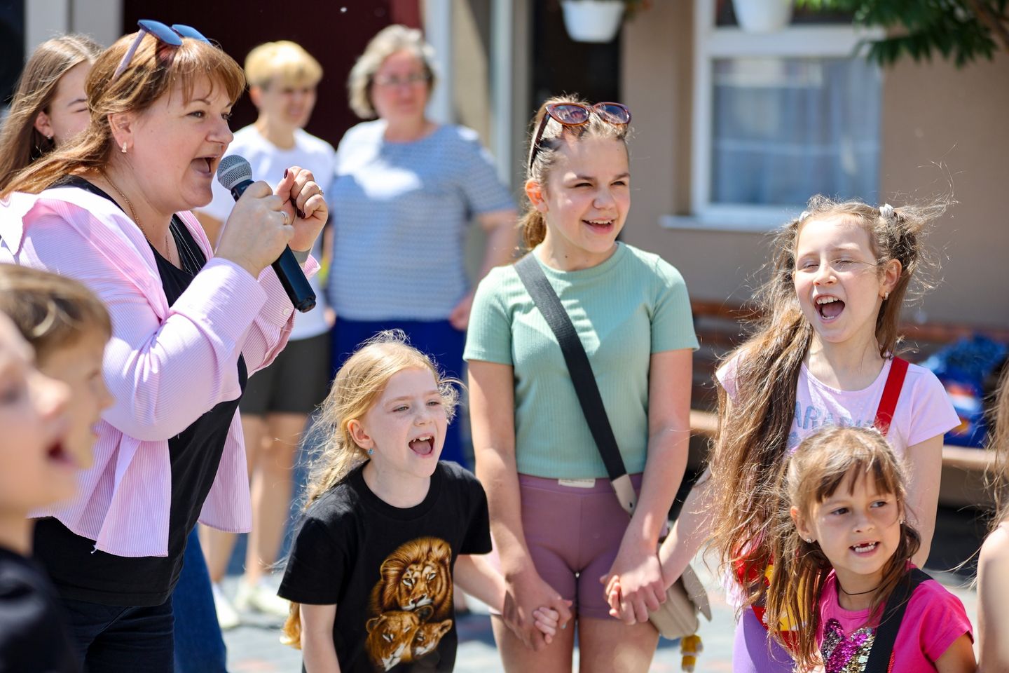 Ukrainian Girls Holding Hands Playing While One Of The Adults Sings Into A Microphone Ukrainian Girls Holding Hands Playing While One Of The Adults Sings Into A Microphone